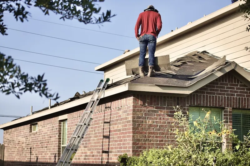 Professional roofer working on a residential roof in Haeckerville